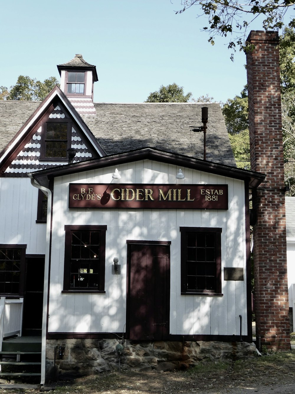 a small white building with a clock tower on top of it