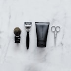 black and silver hair brush beside black soft tube