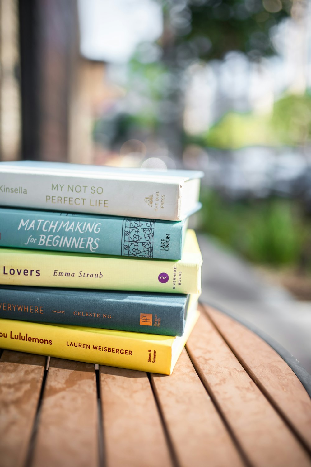 stack of books on brown wooden table