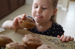 A happy child reaching for a delicious Mary Ann Kitchen single serve plate with a smile in a sunny kitchen setting.