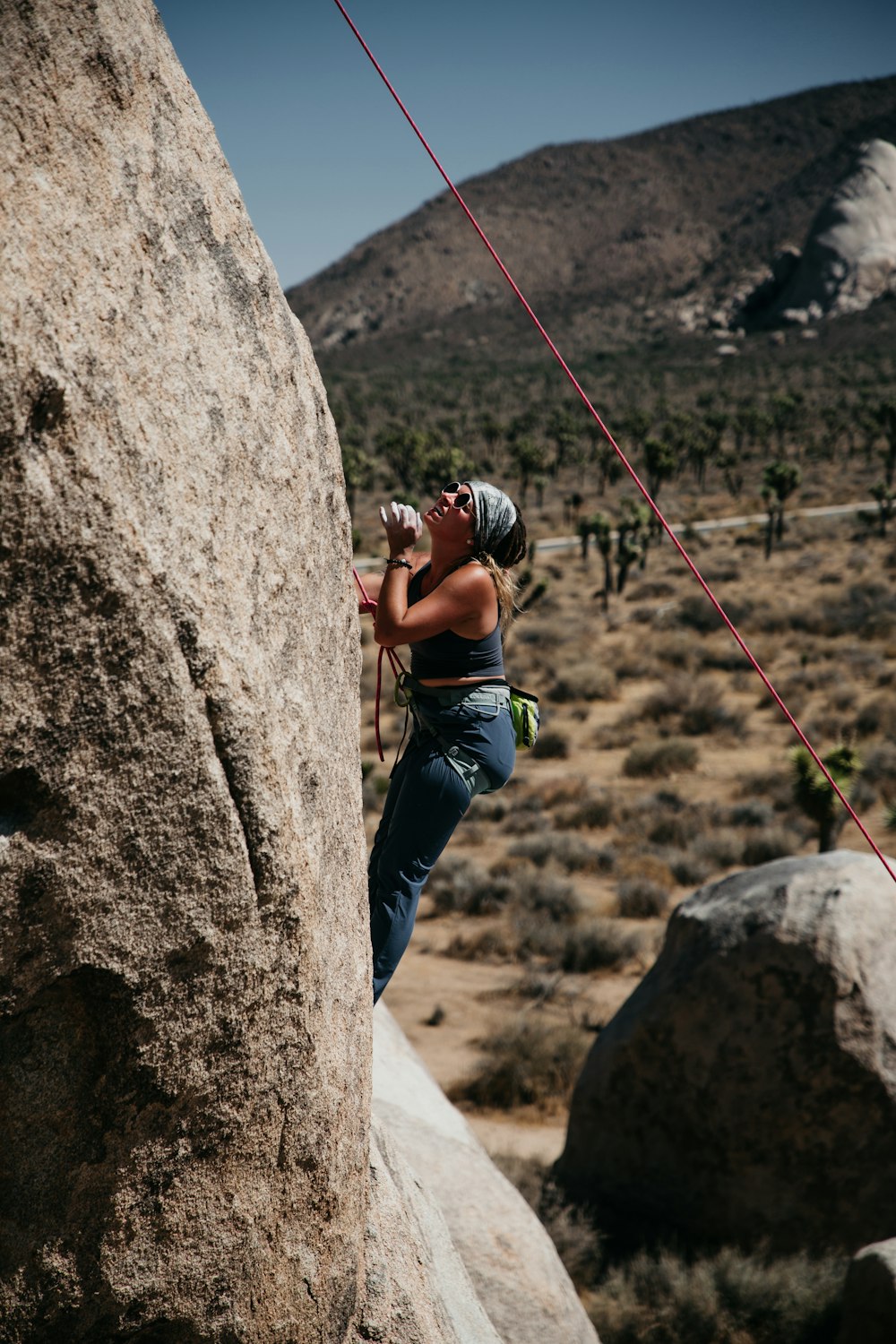 man climbing on brown rock during daytime
