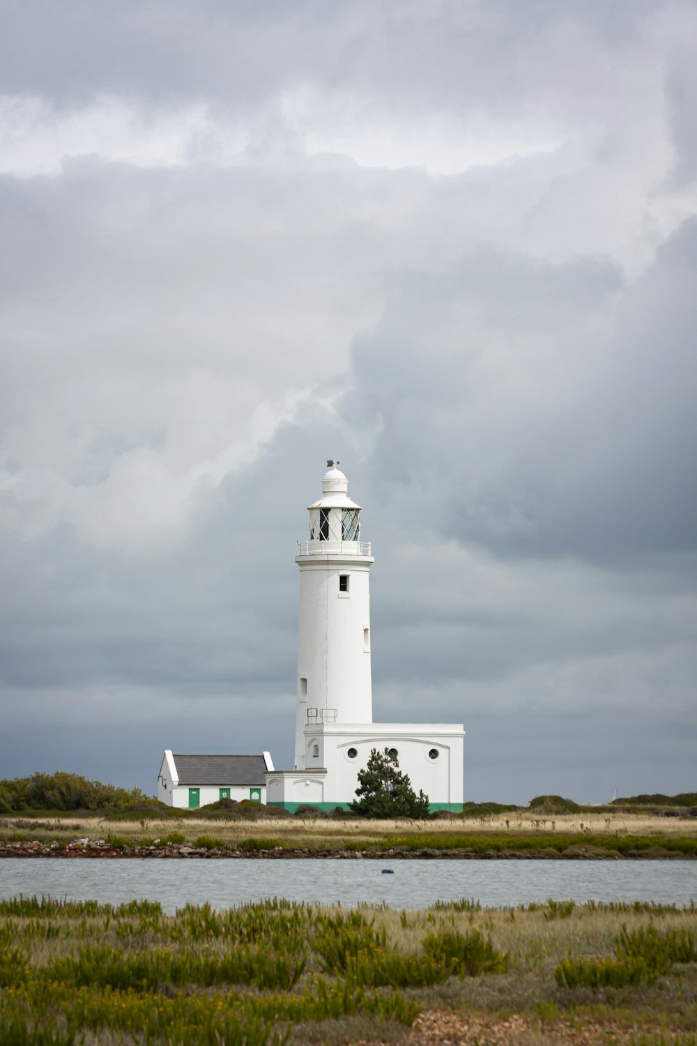 white lighthouse under gray clouds