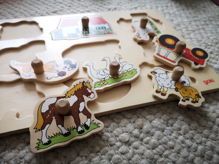 A colorful wooden puzzle with animal shapes designed for toddlers.