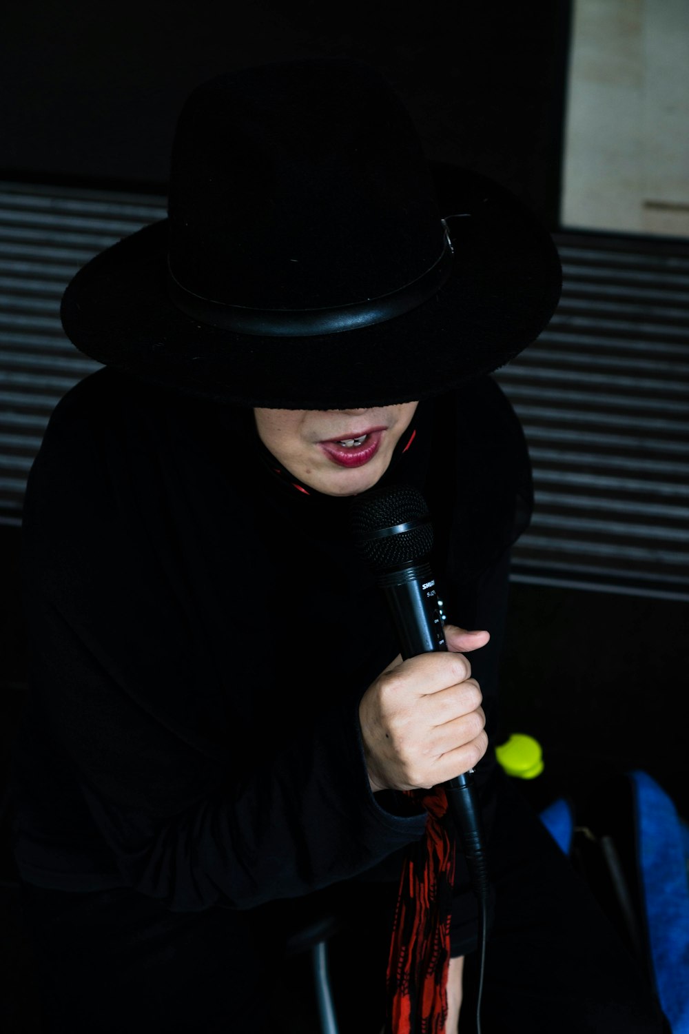 man in black hat holding microphone