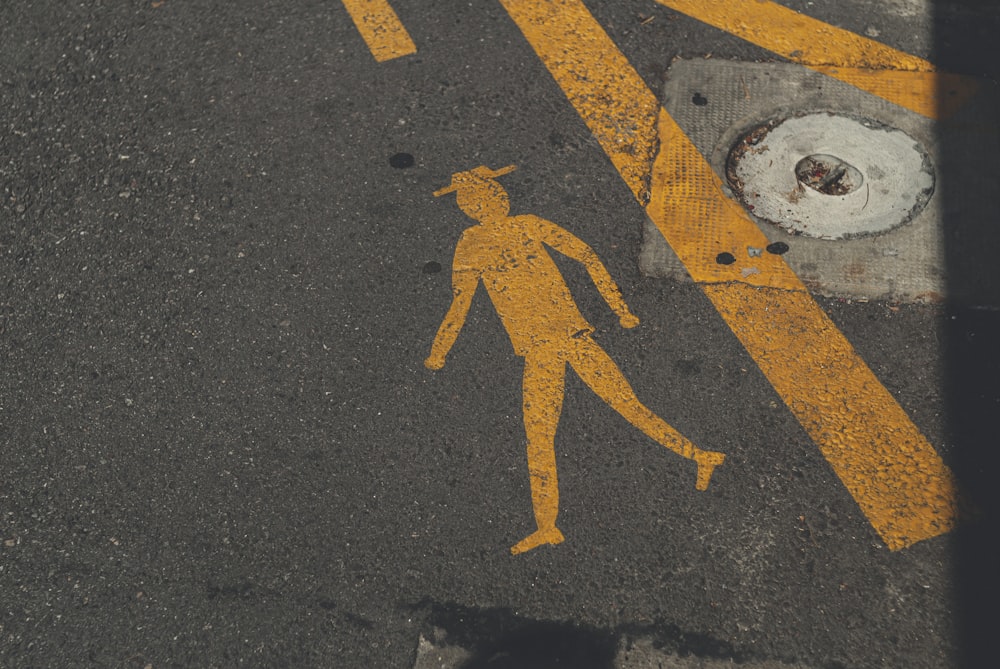 yellow arrow sign on gray asphalt road