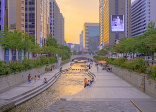 people walking on sidewalk near high rise buildings during daytime