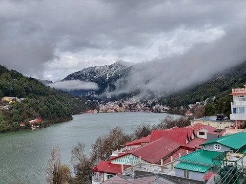 houses near lake and mountain during daytime