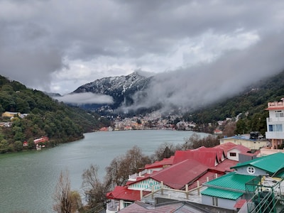 houses near lake and mountain during daytime