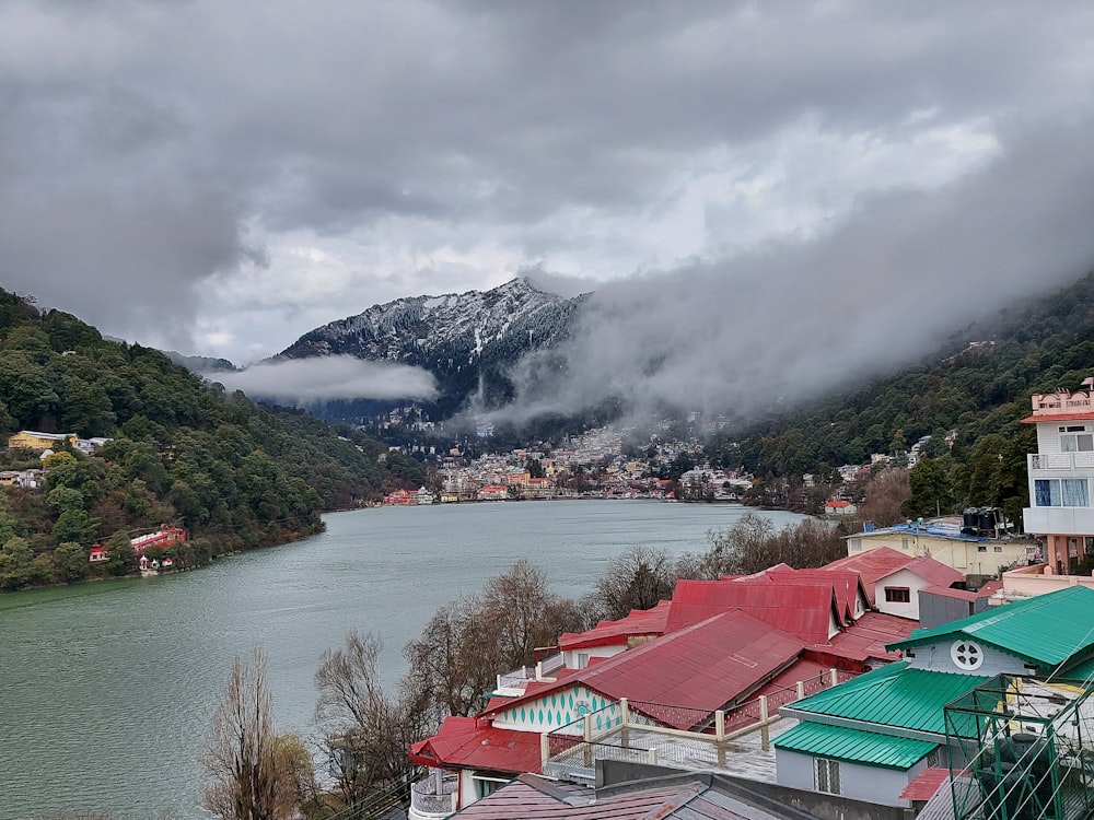 houses near lake and mountain during daytime