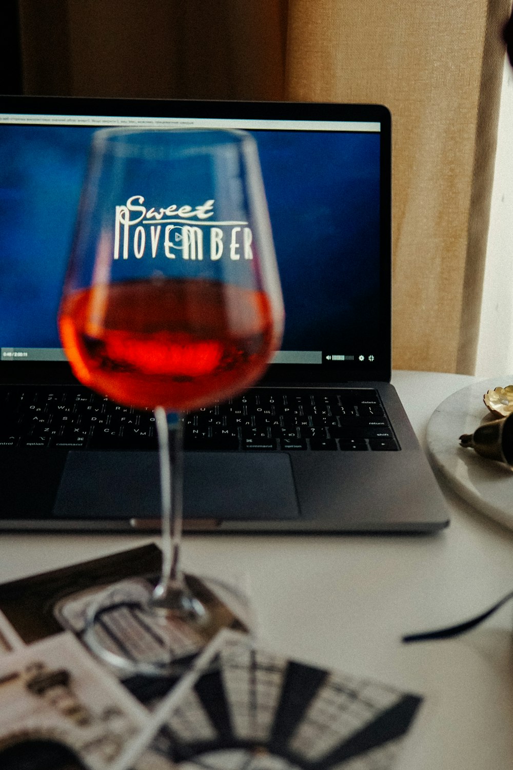 clear wine glass beside black and silver laptop computer