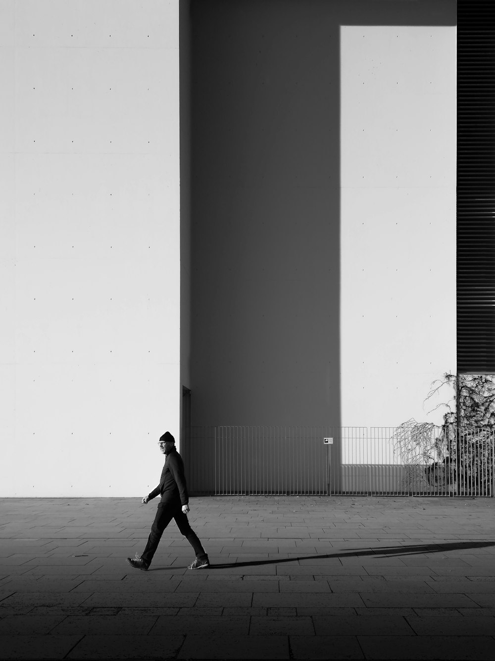 grayscale photo of woman walking on the street
