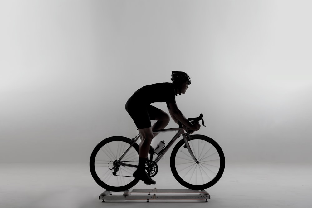 man in black shirt riding on white and orange bmx bike