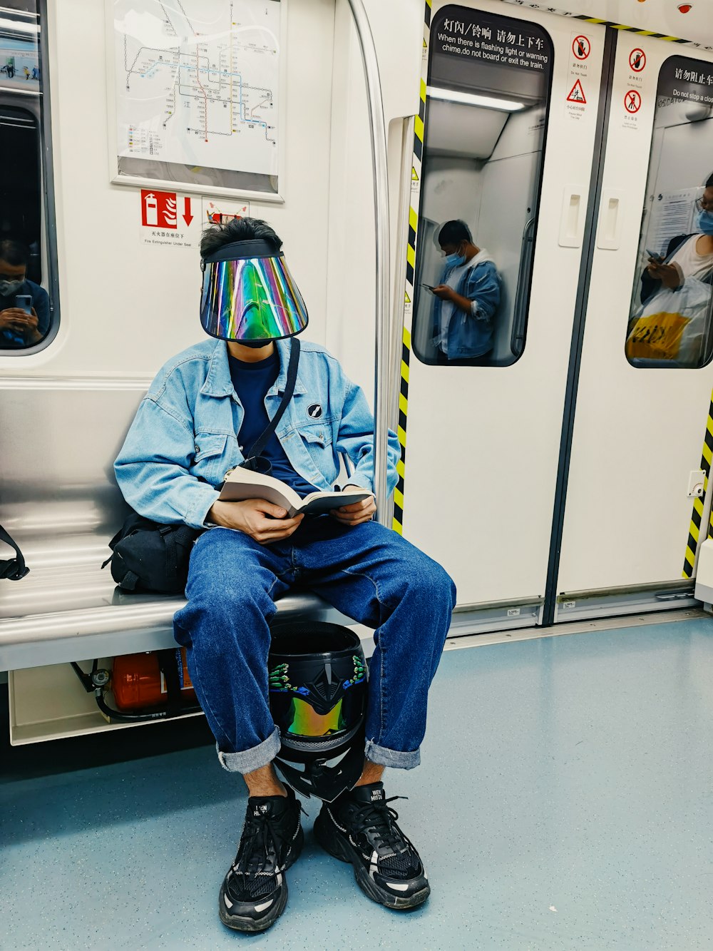 man in blue jacket sitting on train seat