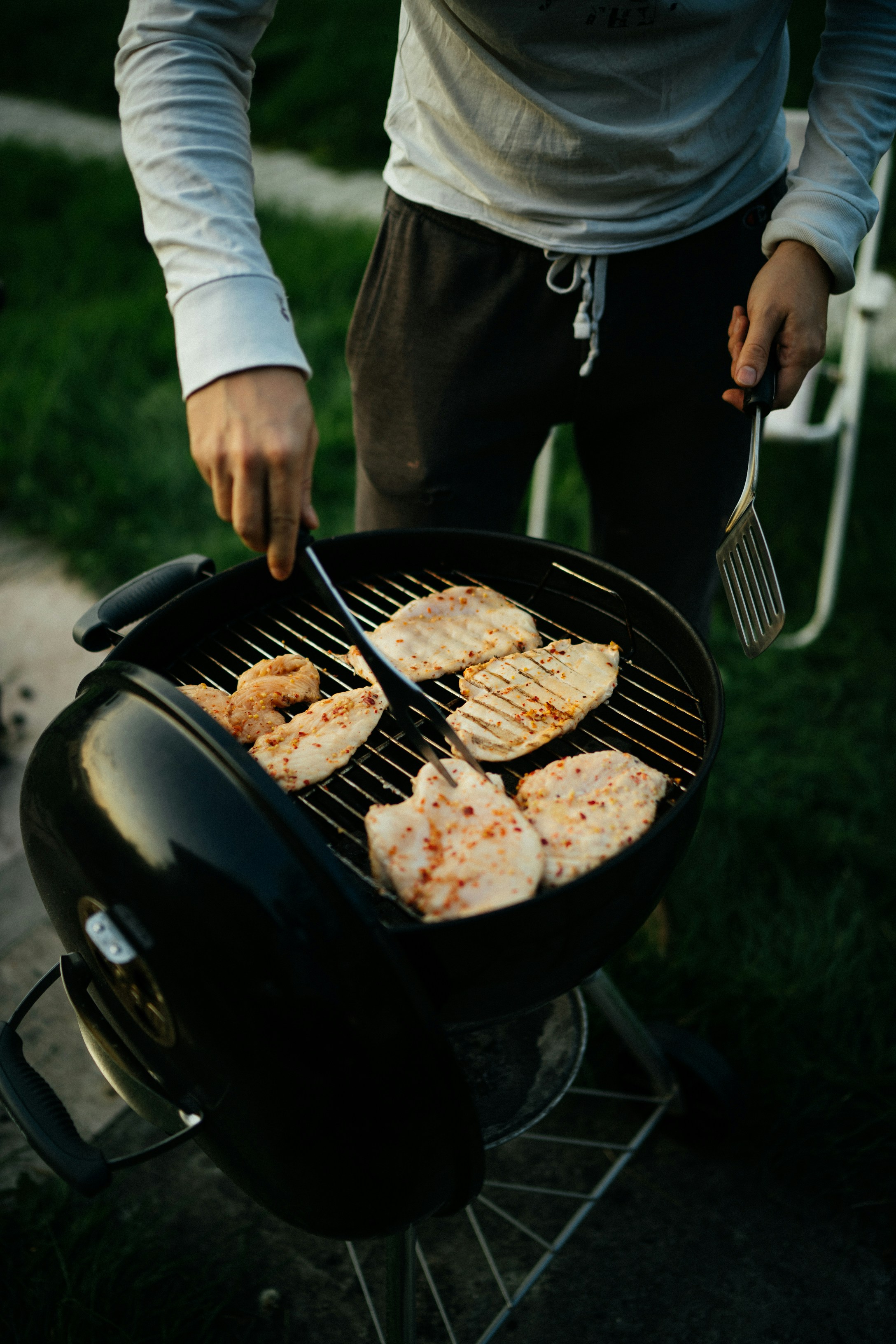 person holding black kettle grill with meat