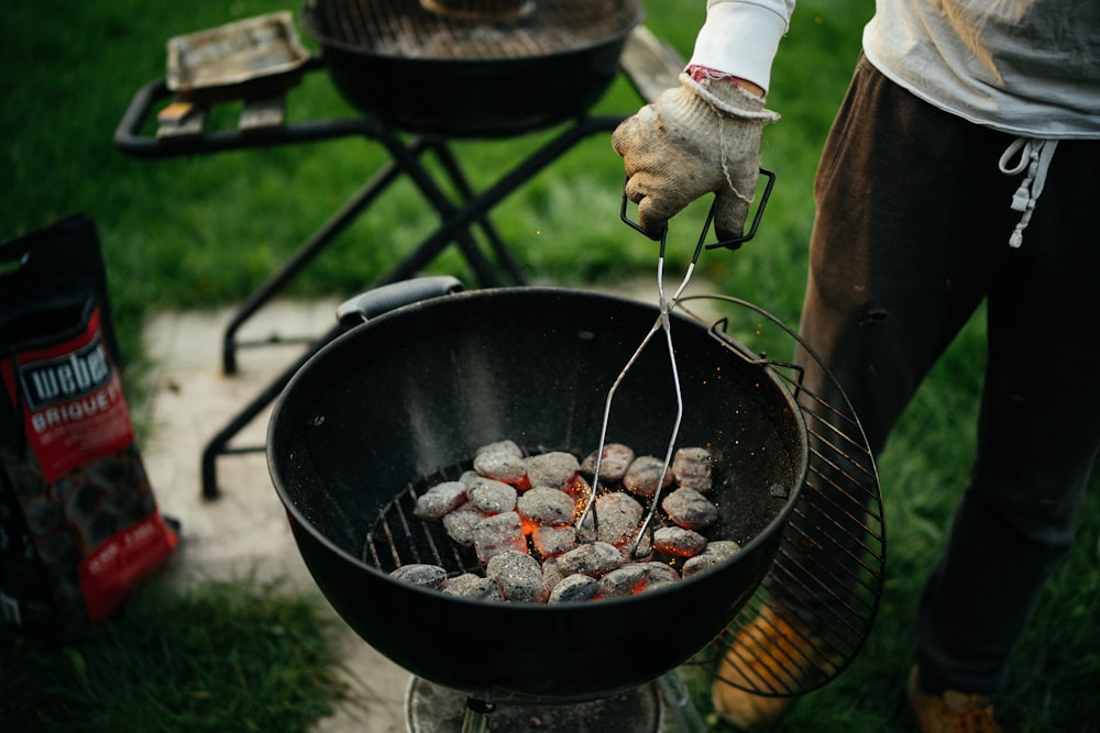 person cooking meat on black round pan