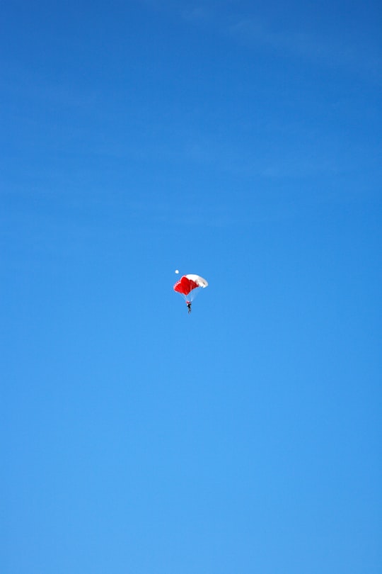 person in red parachute in mid air during daytime in Ras al Khaimah - United Arab Emirates United Arab Emirates