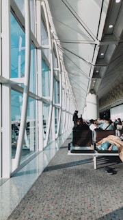An elegant airport terminal lounge bathed in soft natural light, with travelers relaxing.