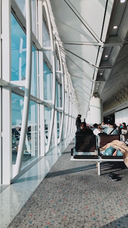 An elegant airport terminal lounge bathed in soft natural light, with travelers relaxing.