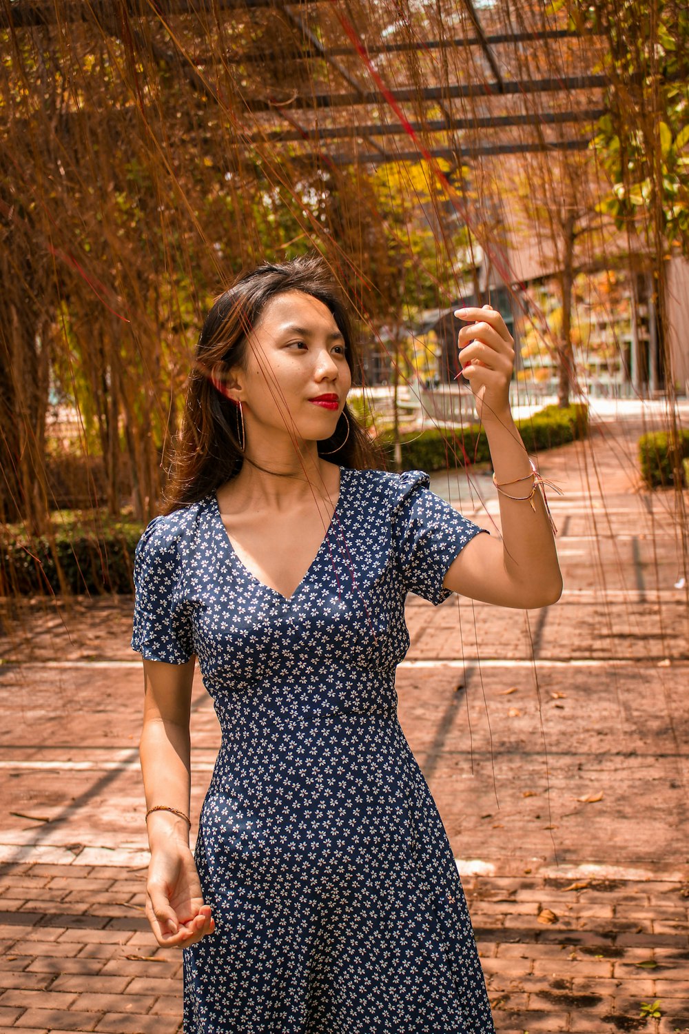 Frau in schwarz-weißem Polka-Dot-Kleid mit klarem Trinkglas