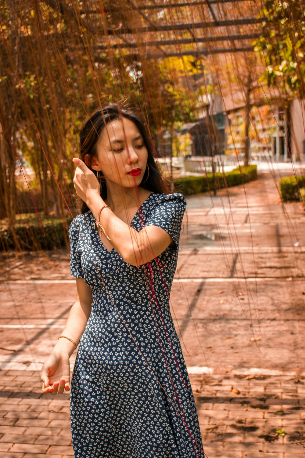 woman in black and white polka dot dress standing on pathway