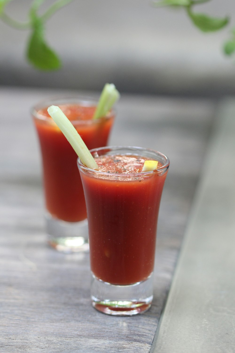 clear drinking glass with red liquid and green straw