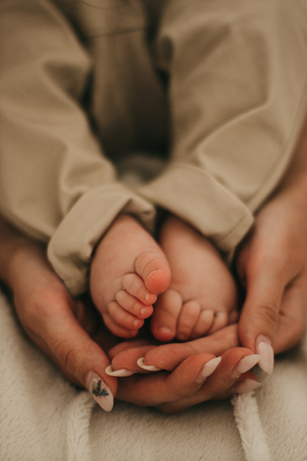 baby in white blanket on persons lap