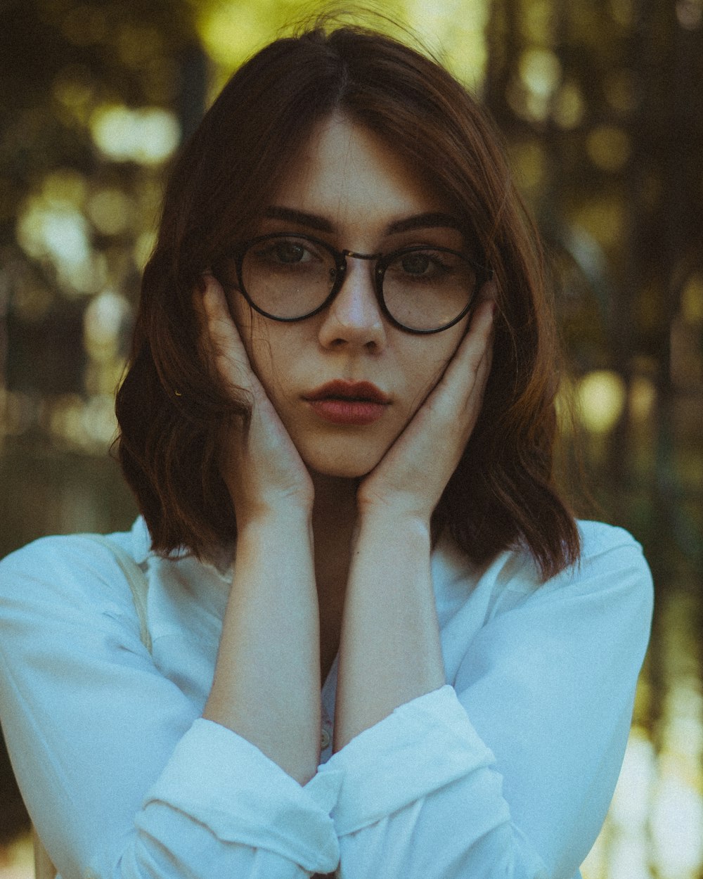 woman in white long sleeve shirt wearing eyeglasses