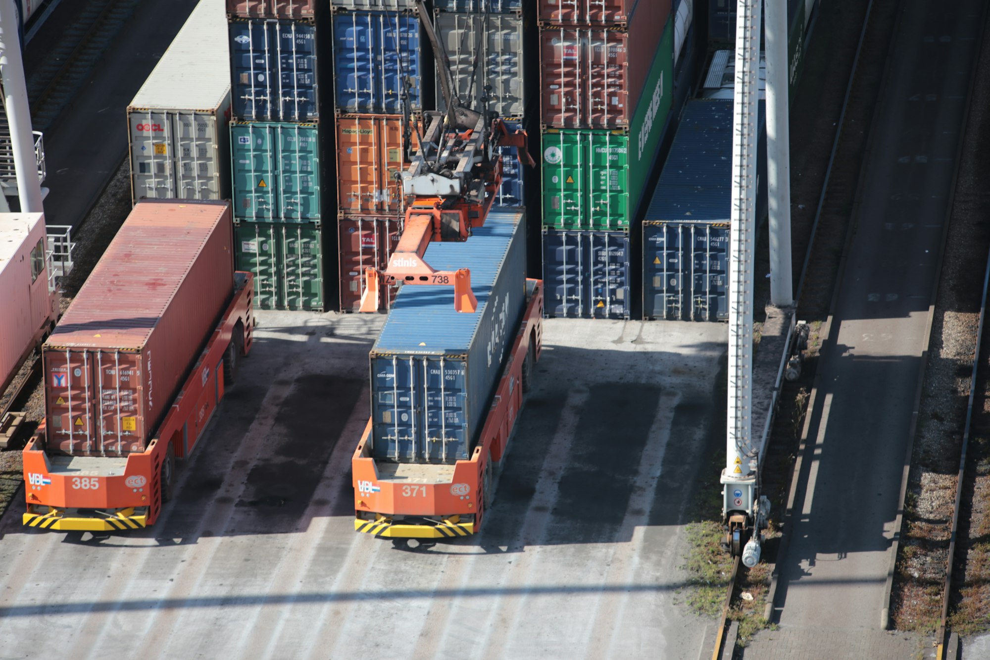 Container being loaded on an Automatic Guided Vehicle at Port of Rotterdam.