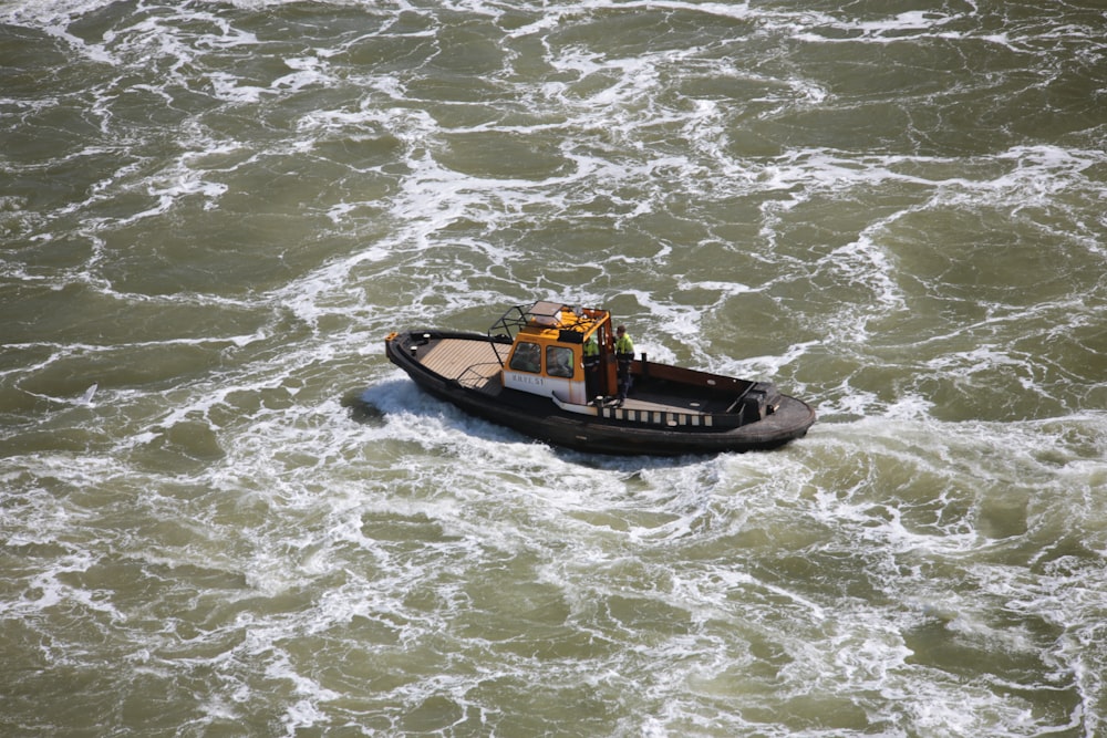 Braunes und schwarzes Boot tagsüber auf dem Wasser