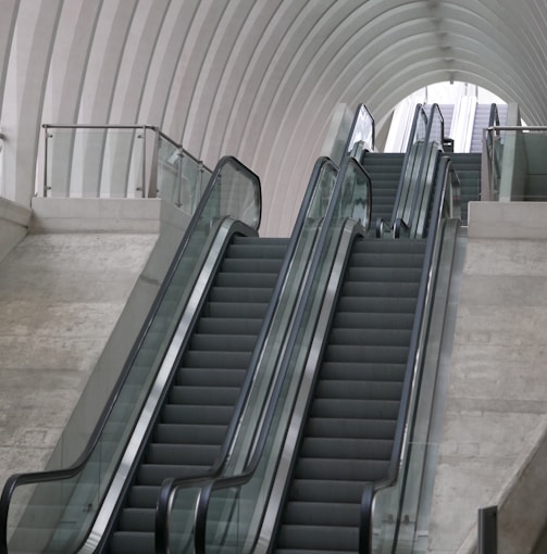 gray escalator inside white building