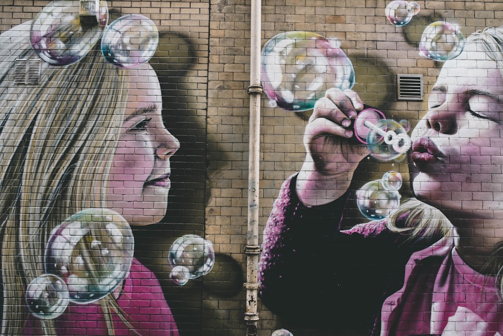 woman in black and pink floral shirt blowing bubbles