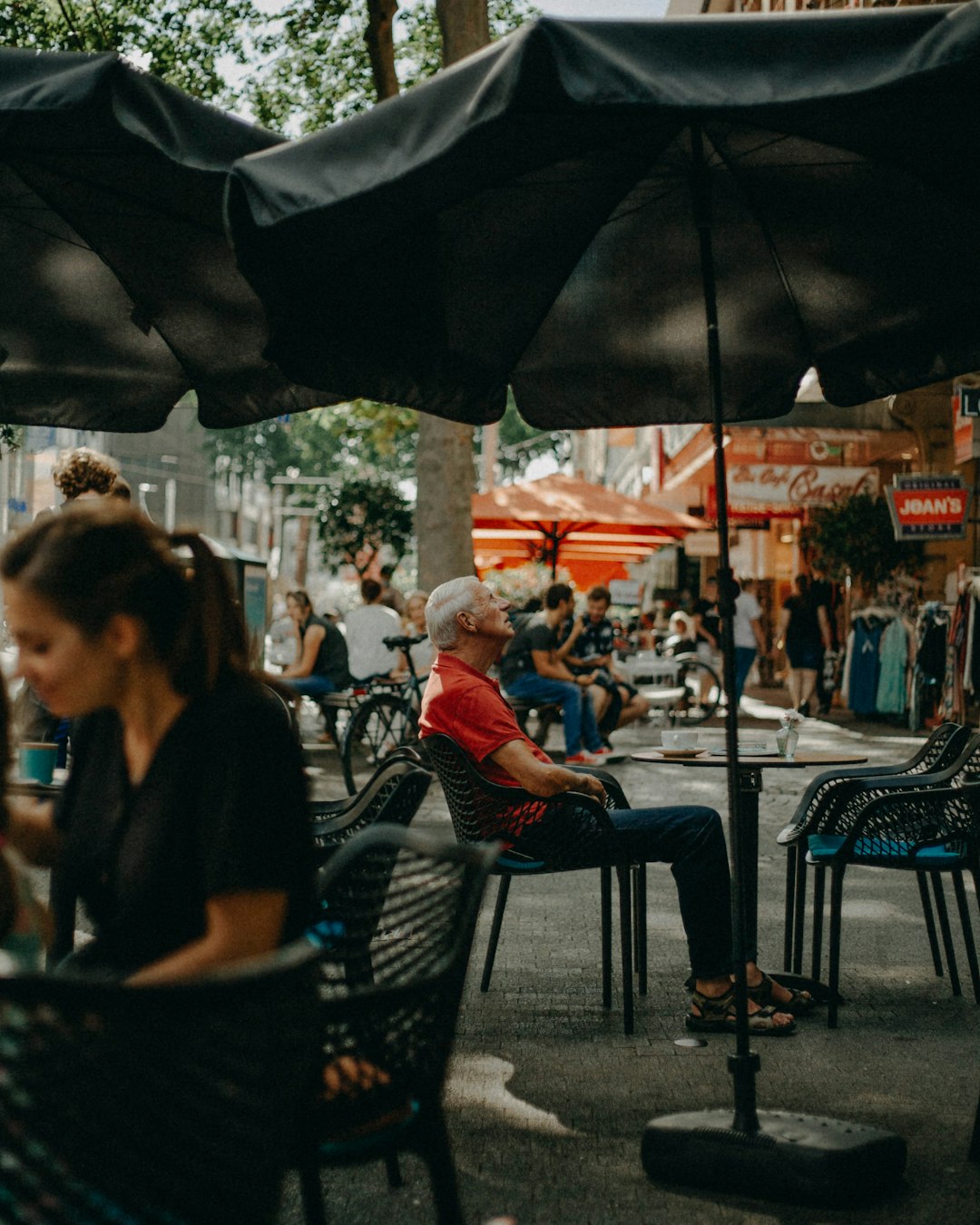 people sitting on black metal chairs during daytime