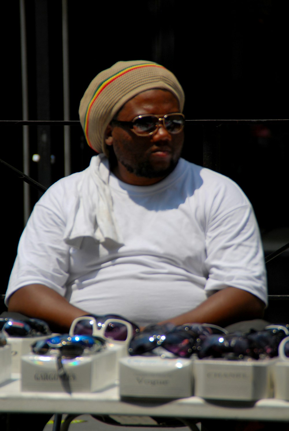 man in white crew neck t-shirt wearing yellow and white knit cap sitting on chair