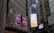 Tall urban buildings with large digital billboards displaying advertisements. One billboard shows a close-up of a face with an expressive emotion, and another displays a clock advertisement.