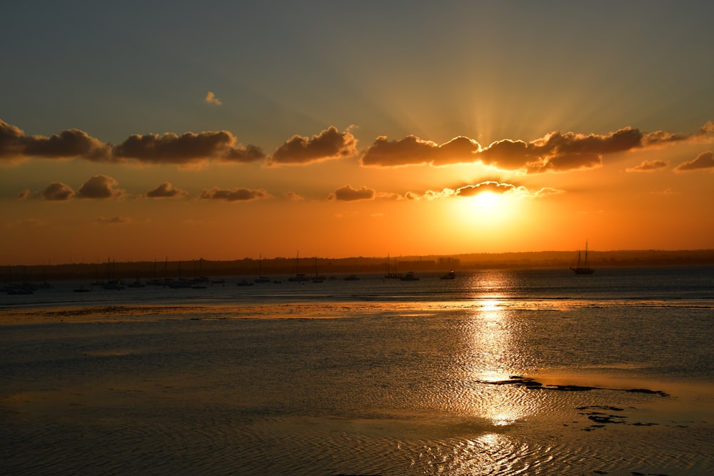 body of water under cloudy sky during sunset