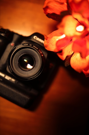 Close-up of a camera lens focused on a beautifully arranged Raya-themed setup with beige and white tones.