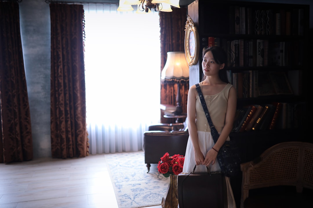 woman in white sleeveless dress standing beside brown wooden table