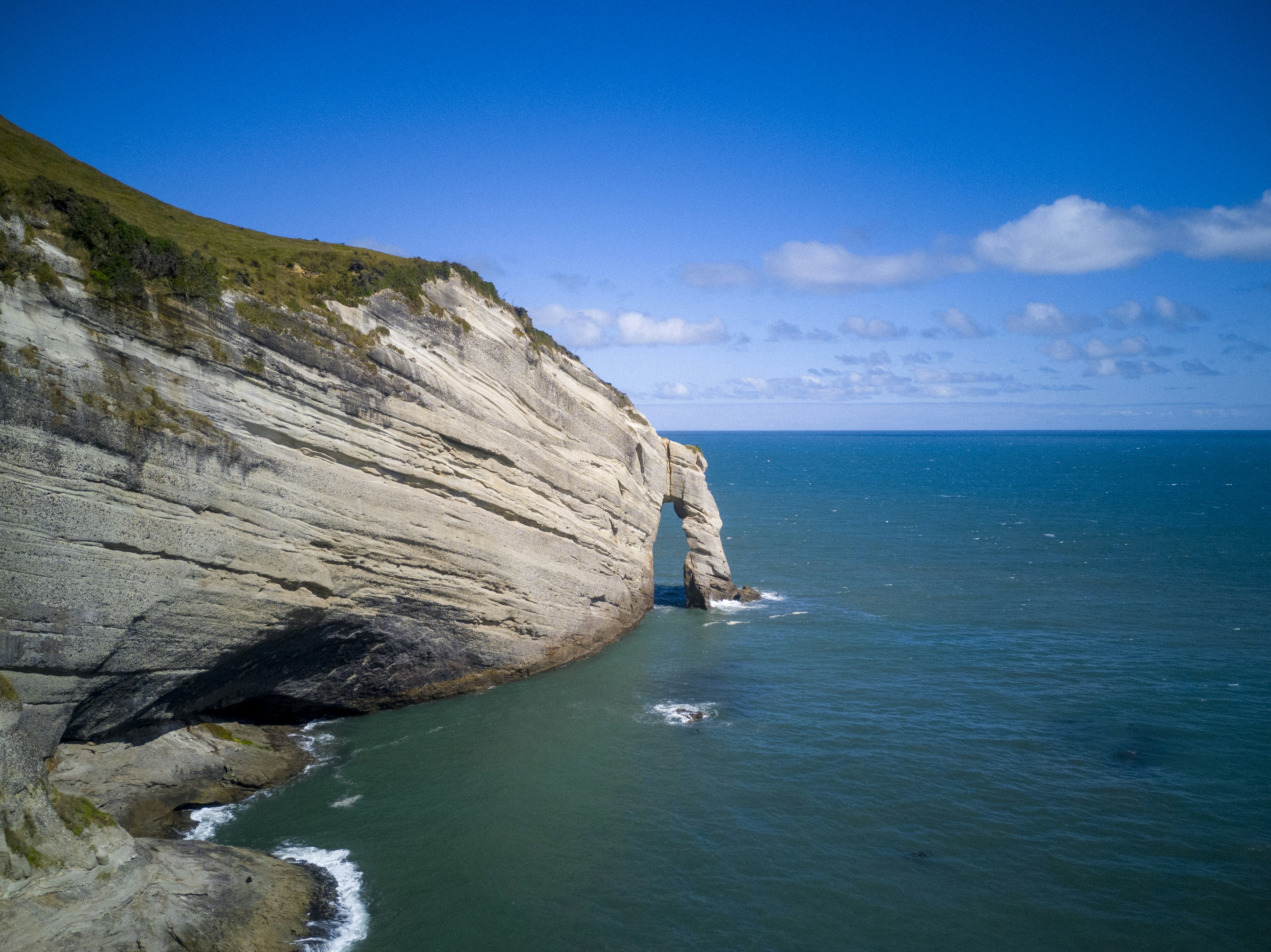 brown rock formation near body of water during daytime