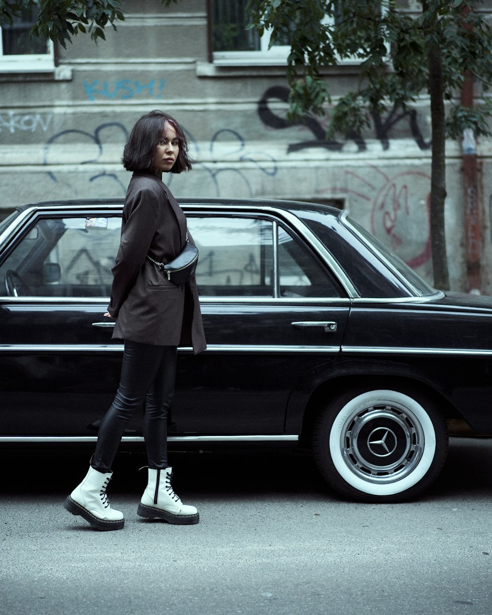 Donna in cappotto nero in piedi accanto all'auto nera durante il giorno  foto – Persona Immagine gratuita su Unsplash