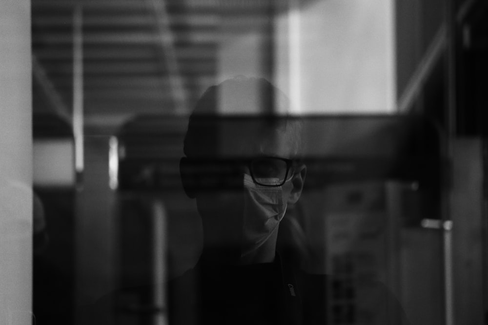 Photo en niveaux de gris d’une femme portant des lunettes