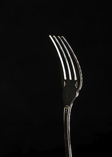stainless steel fork with black background