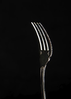 stainless steel fork with black background