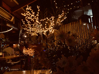 An intimate restaurant corner with soft lighting, a chef plating food, and a camera capturing the moment.