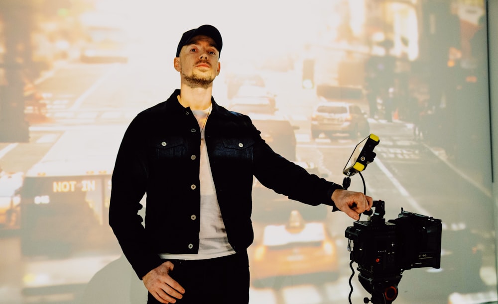 man in black button up jacket holding black dslr camera