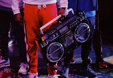 man in red jacket holding black dj controller