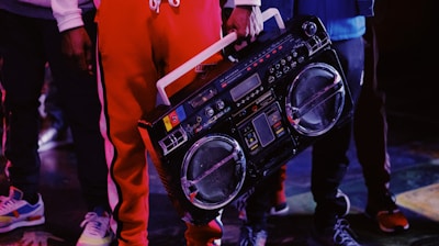 man in red jacket holding black dj controller