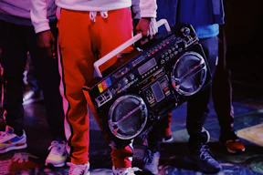 man in red jacket holding black dj controller