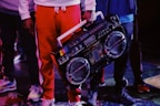 man in red jacket holding black dj controller