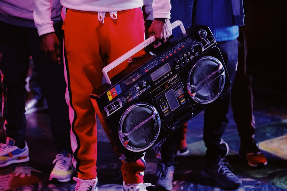 Hombre con chaqueta roja sosteniendo un controlador de DJ negro