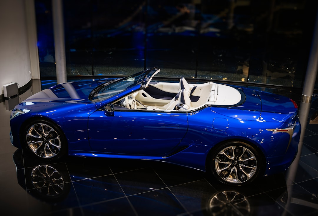 blue convertible coupe parked on black floor